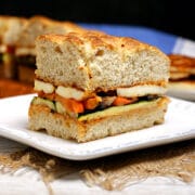 A Roasted Vegetable and Halloumi Sandwich on a white plate.