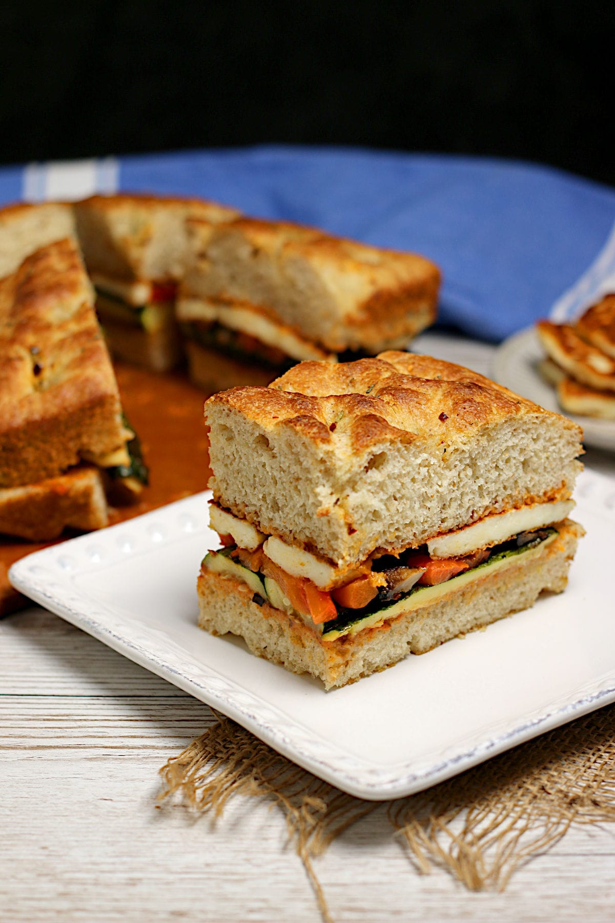 A Roasted Vegetable and Halloumi Sandwich on a white plate.