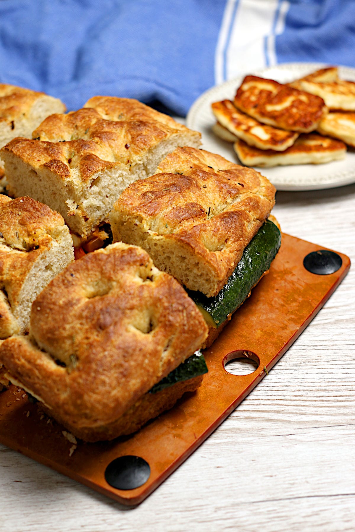 Several pieces of Roasted Vegetable and Halloumi Sandwich on a cutting board.