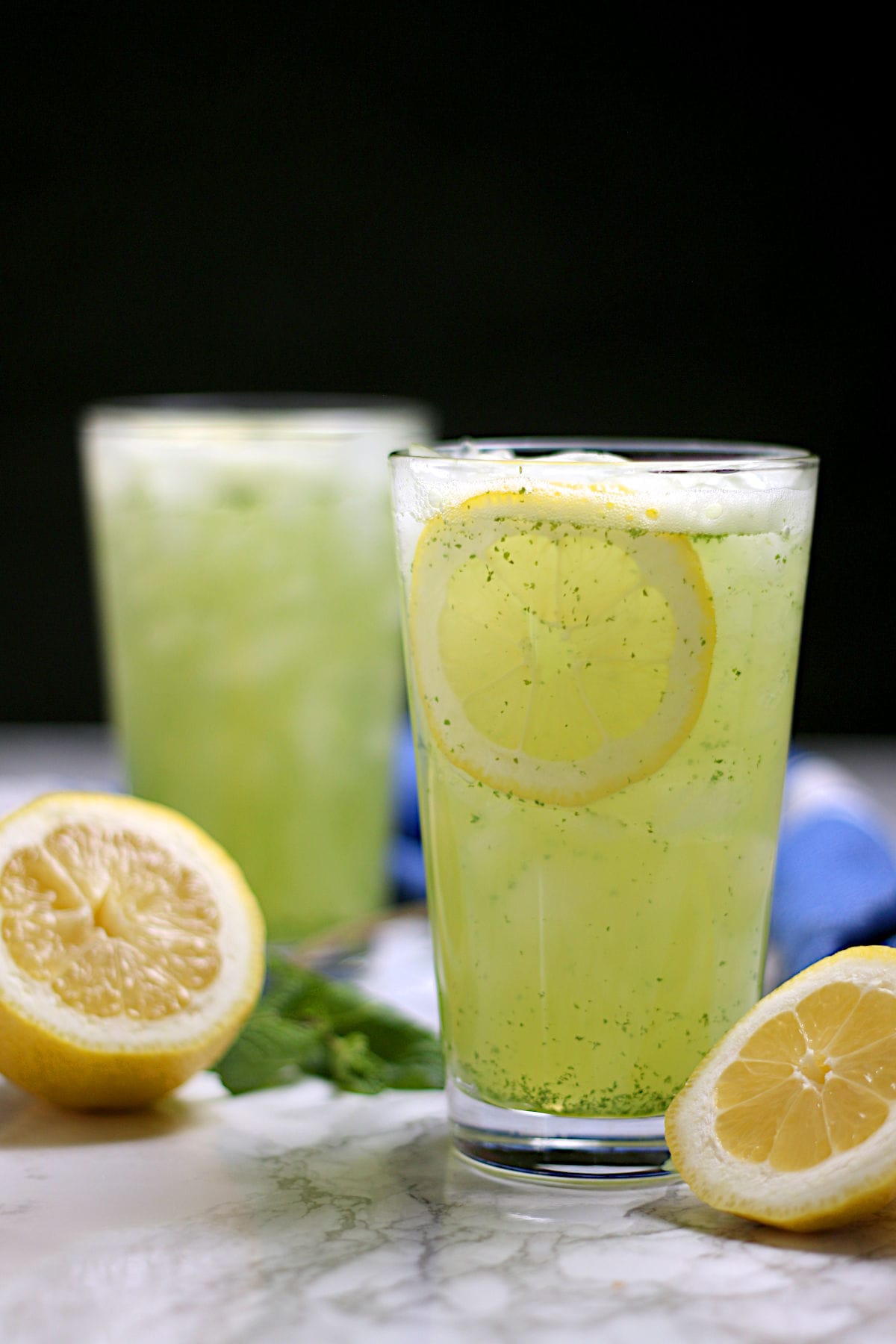 Two glasses of Middle Eastern Mint Lemonade with ice.