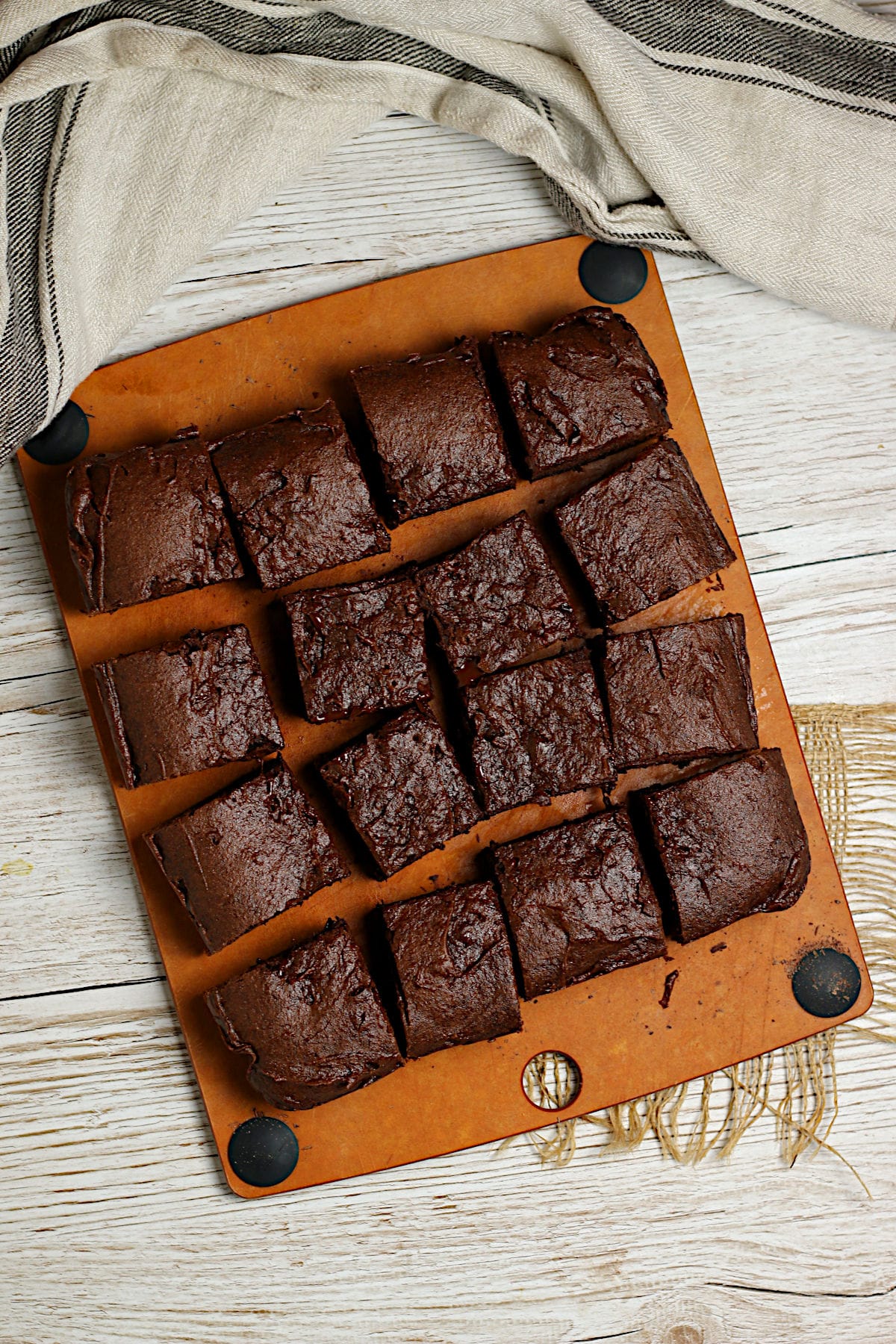 An overhead photo of a batch of Mocha Fudge Vegan Brownies cut into squares on a cutting board.