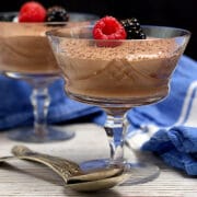 A crystal goblet containing Cottage Cheese Chocolate Mousse garnished with berries and shaved chocolate.