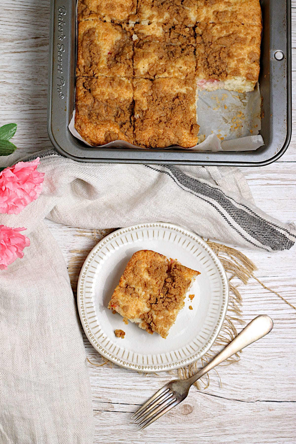 An overhead photo of a slice of Greek Yogurt Rhubarb Coffee Cake on a small white plate.