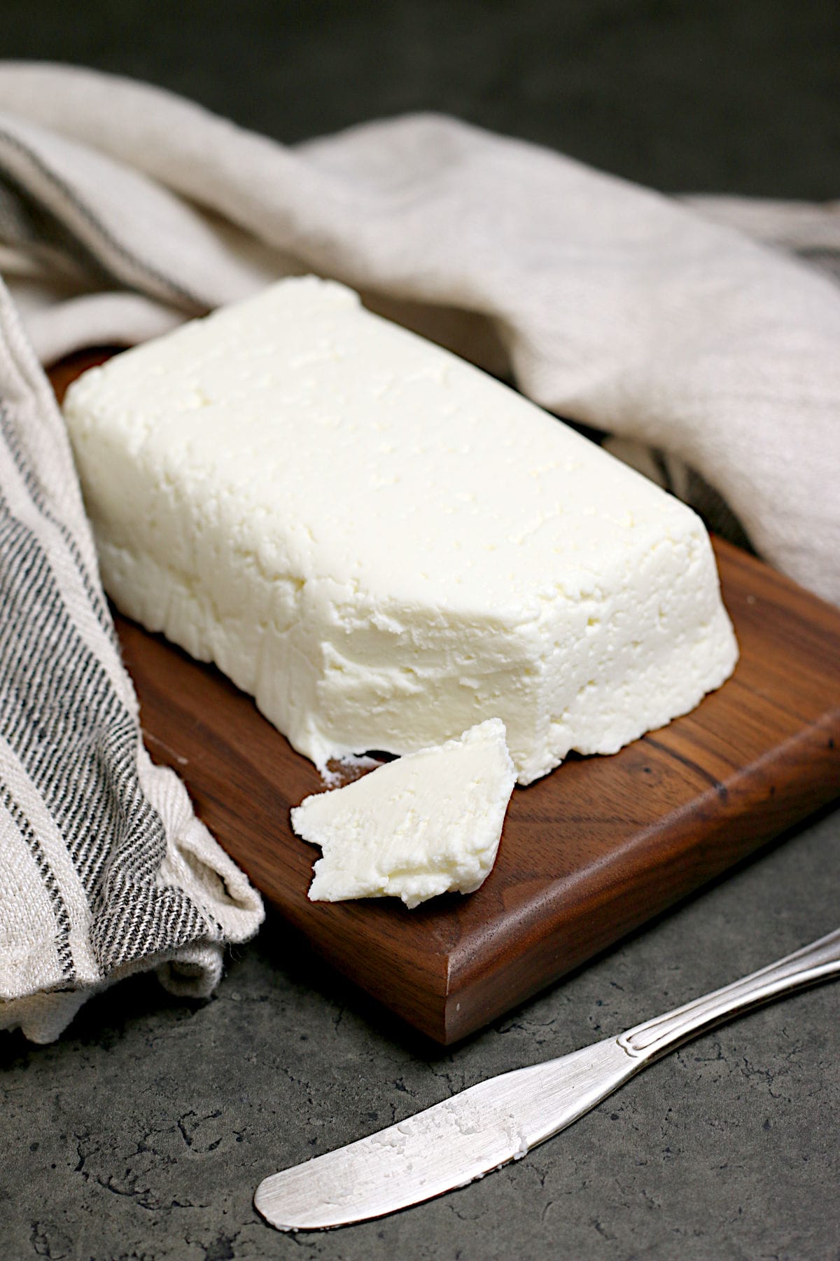 A block of Homemade Queso Fresco on a small wood cutting board.