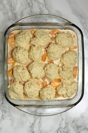 Peaches and Cream Cobbler in a glass baking dish before baking.