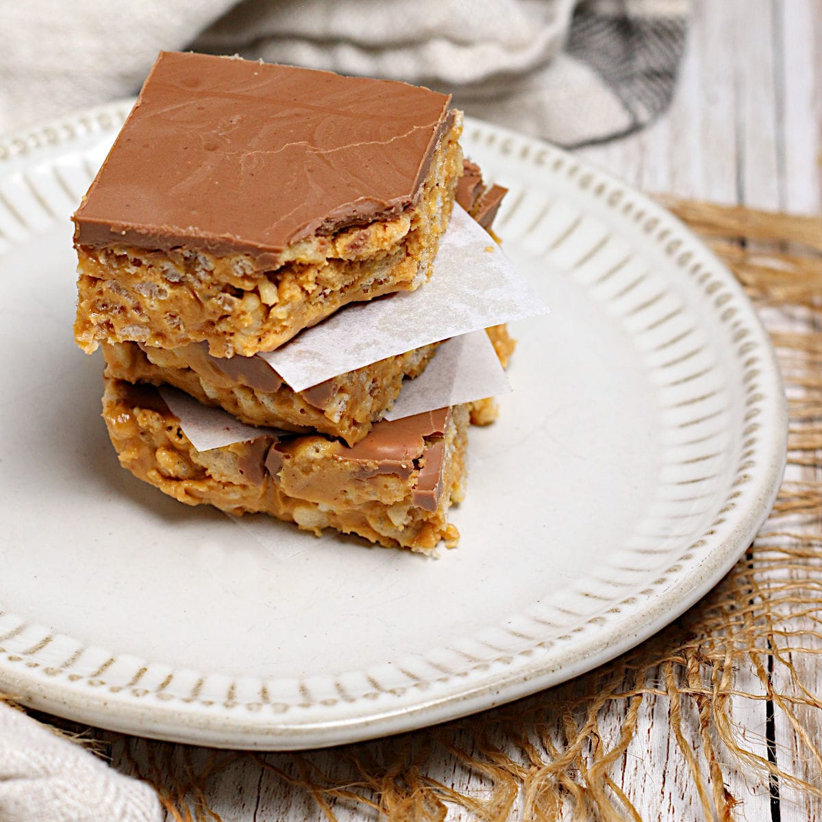 Chocolate Peanut Butter Crunch Bars A stack of Chocolate Peanut Butter Crunch Bars, with a bite missing from the top piece.