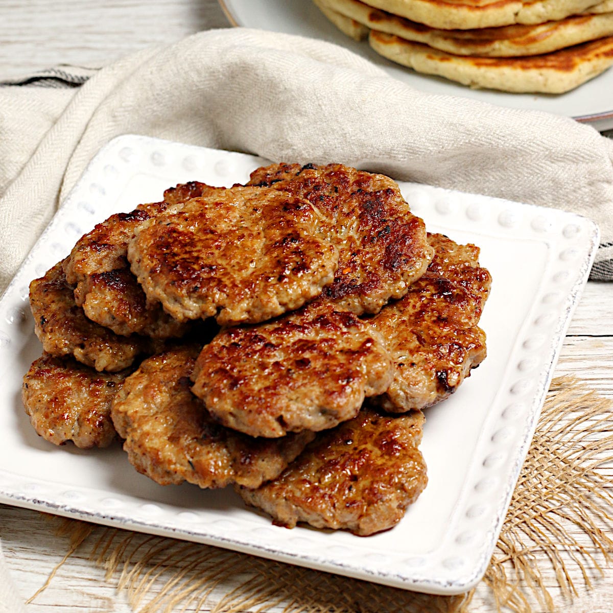 A stack of Homemade Breakfast Sausage Patties on a white plate.