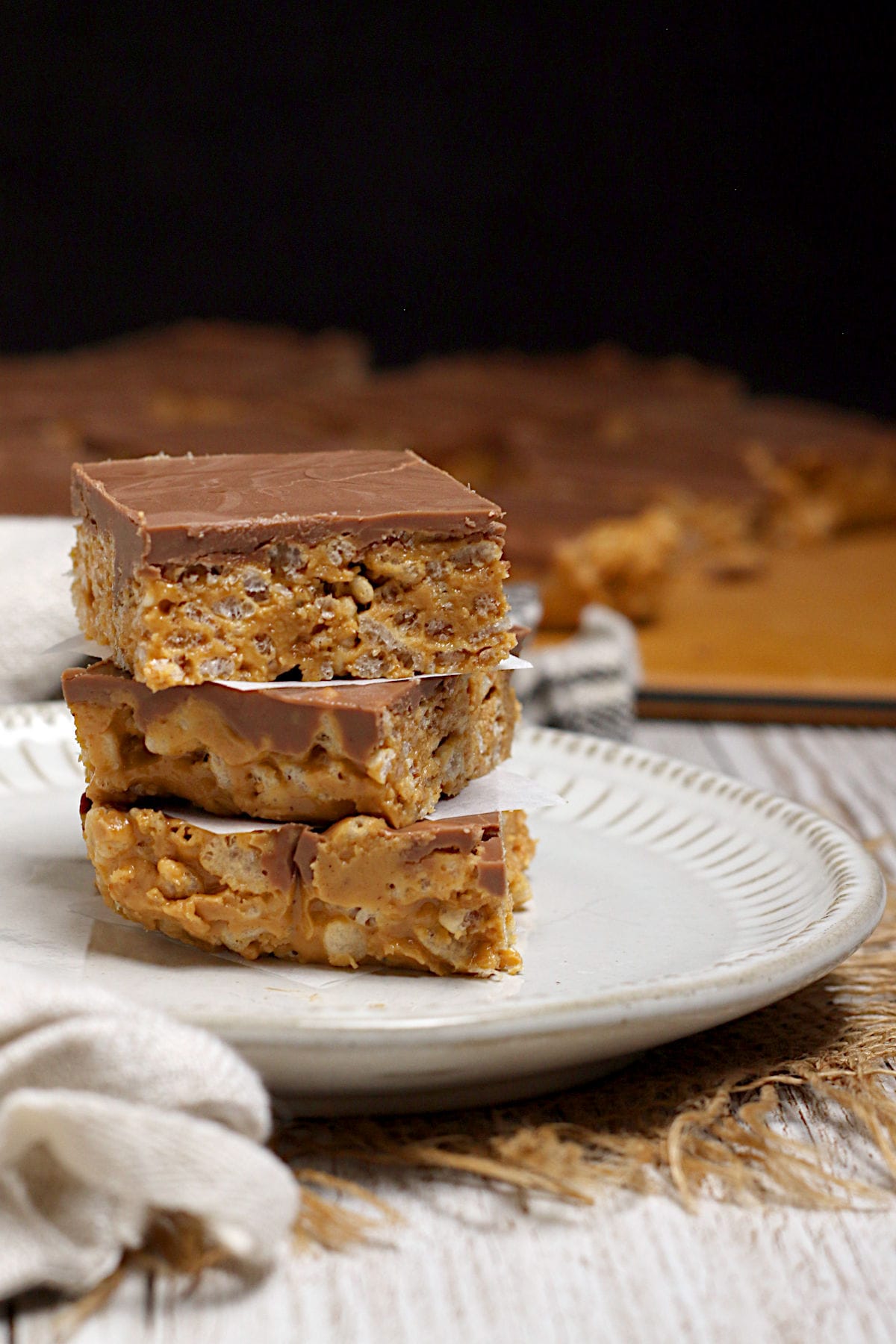 Chocolate Peanut Butter Crunch Bars A stack of Chocolate Peanut Butter Crunch Bars on a small white plate.