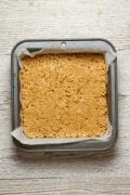 Chocolate Peanut Butter Crunch Bars An overhead photo of the peanut butter crunch layer of Chocolate Peanut Butter Crunch Bars in an 8x8" pan.