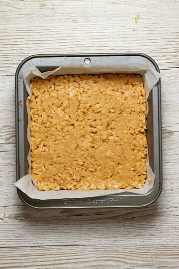 An overhead photo of the peanut butter crunch layer of Chocolate Peanut Butter Crunch Bars in an 8x8" pan.