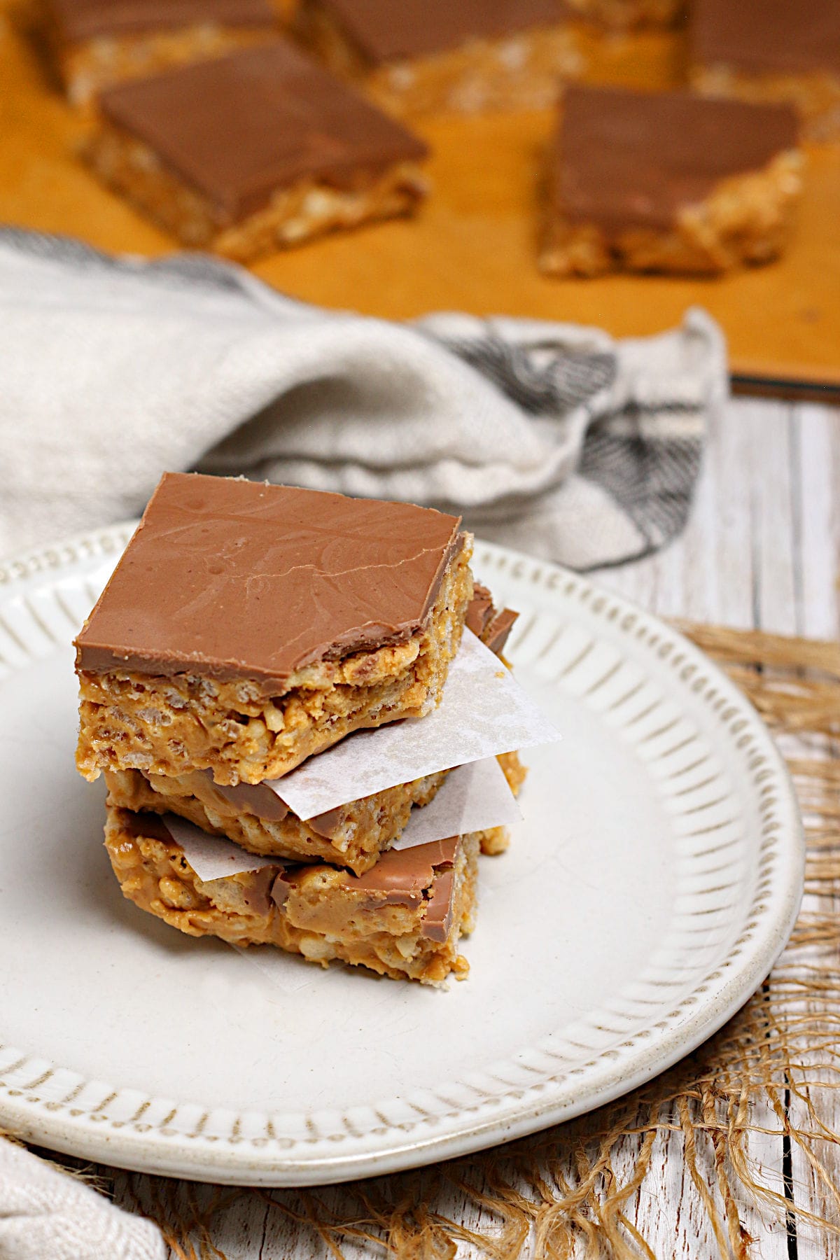 Chocolate Peanut Butter Crunch Bars A stack of Chocolate Peanut Butter Crunch Bars, with a bite missing from the top piece.