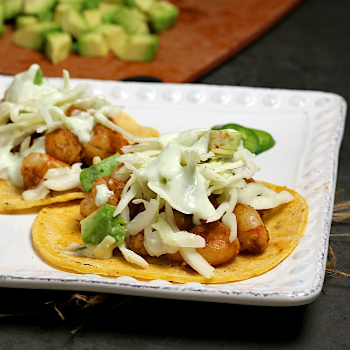 A closeup photo of two Shrimp Tacos with Cilantro Lime Slaw on a white plate.