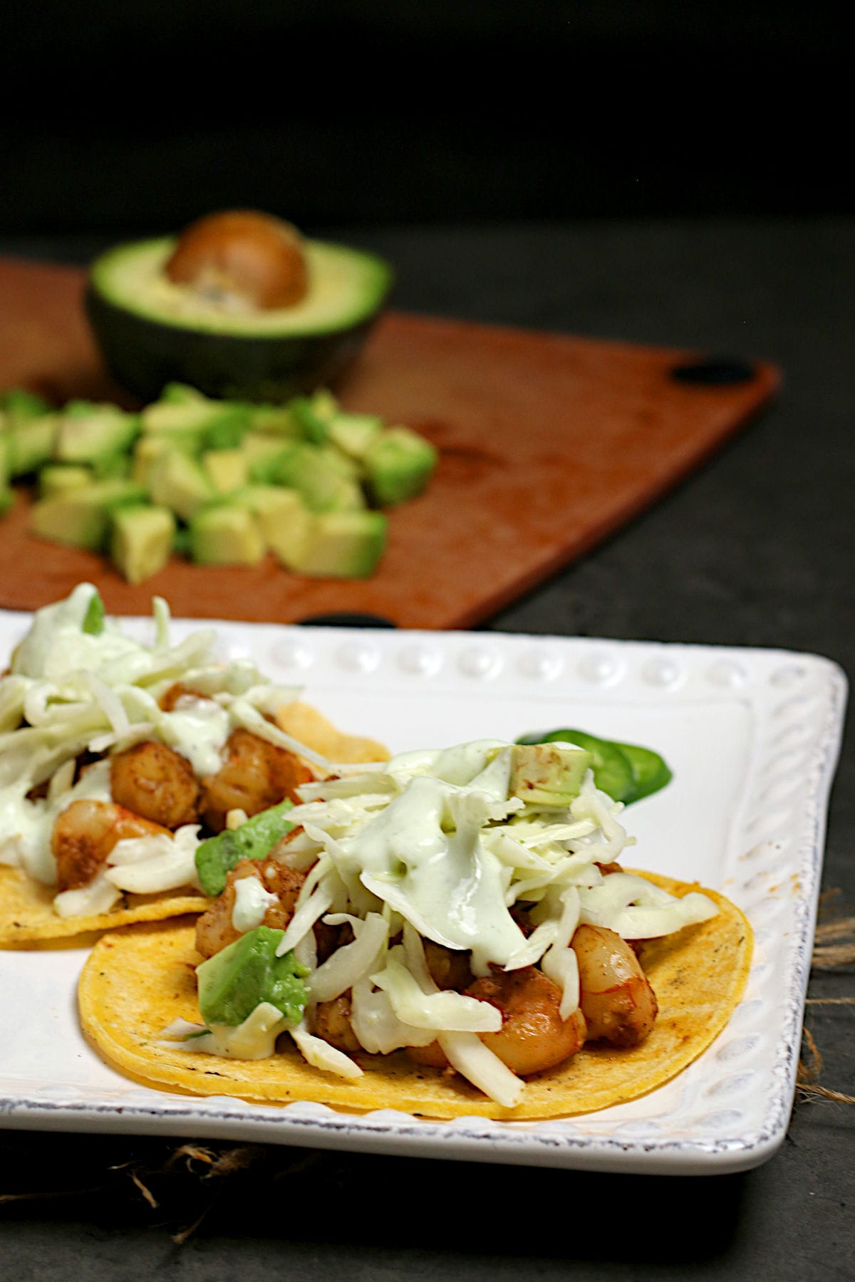 A closeup photo of two Shrimp Tacos with Cilantro Lime Slaw on a white plate.