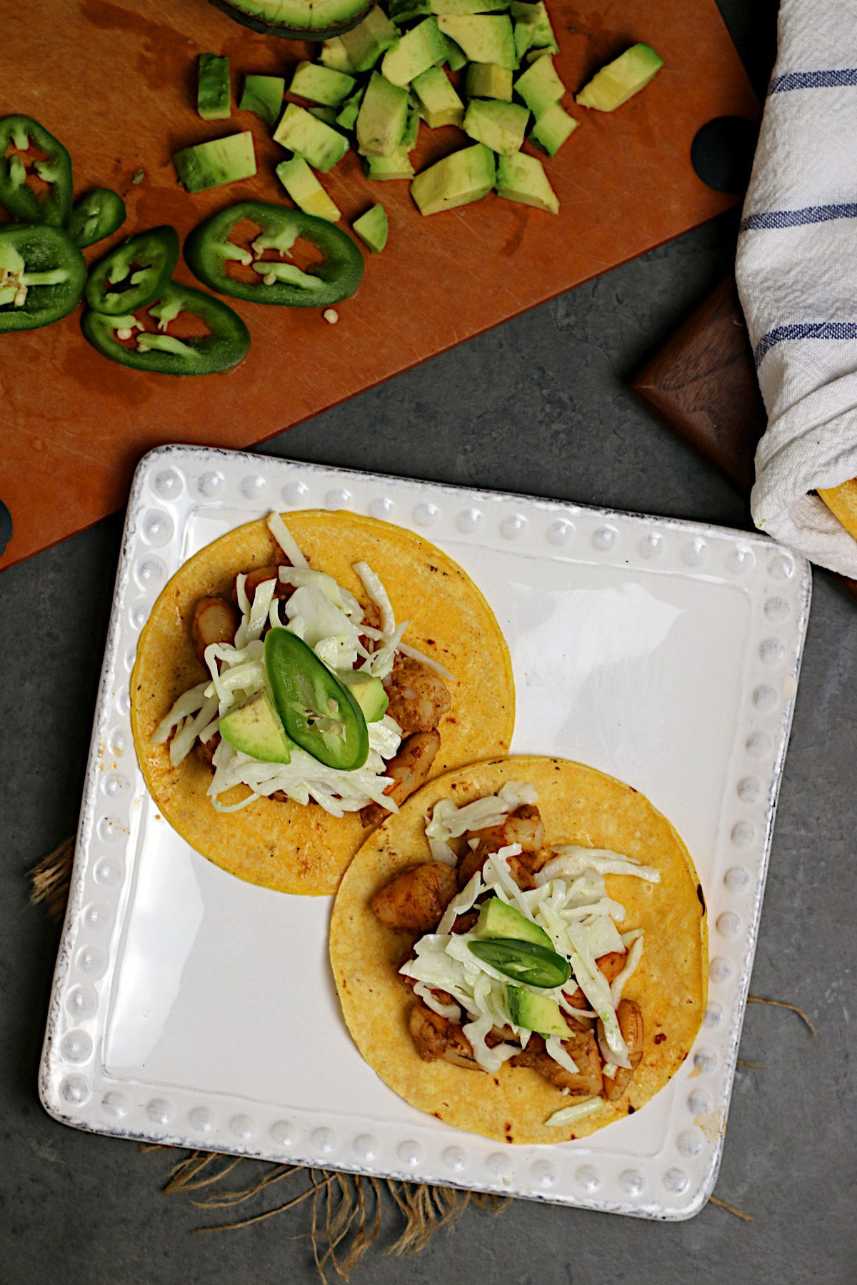 An overhead photo of two Shrimp Tacos with Cilantro Lime Slaw on a white plate.