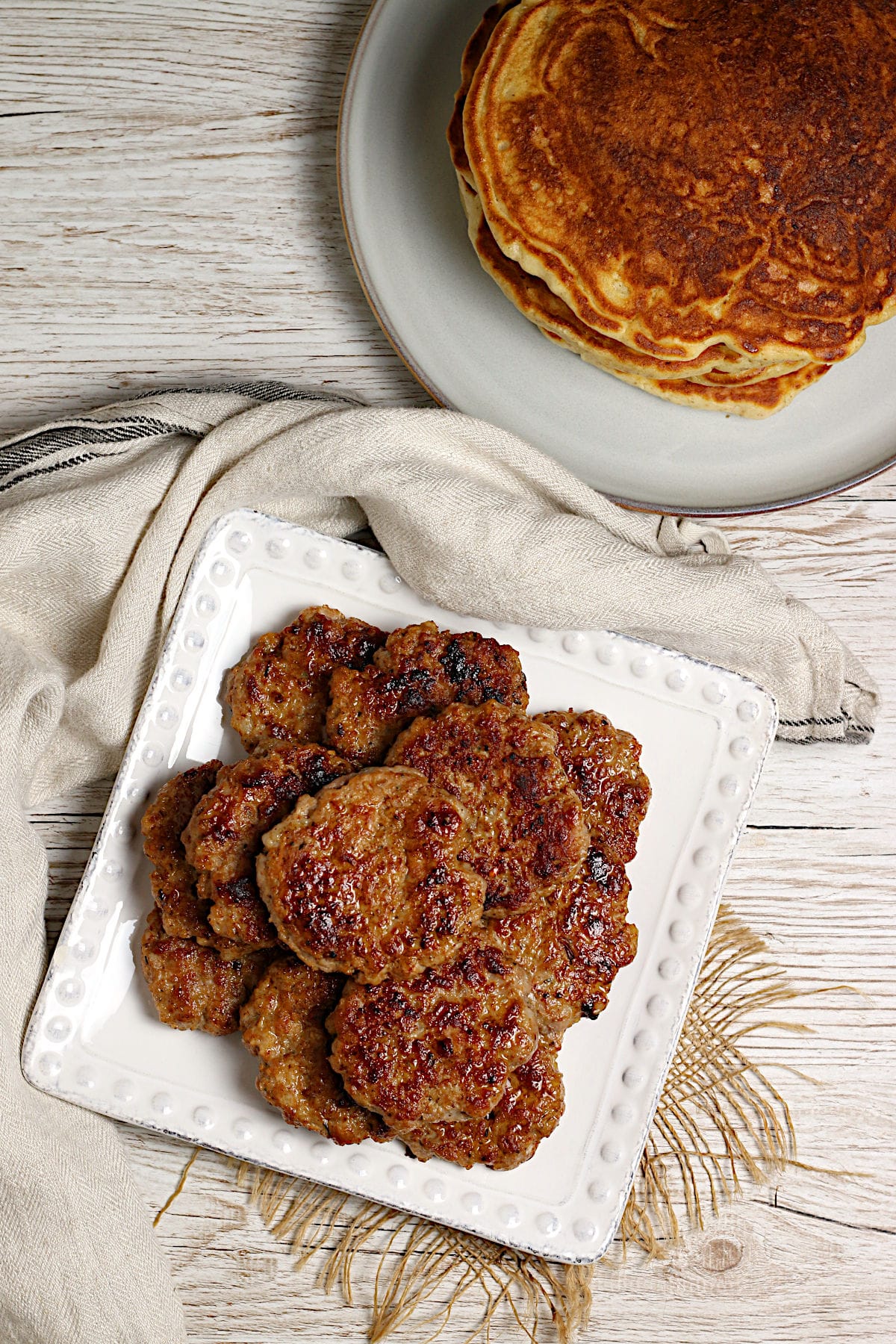 An overhead photo of a stack of Homemade Breakfast Sausage Patties on a white plate.