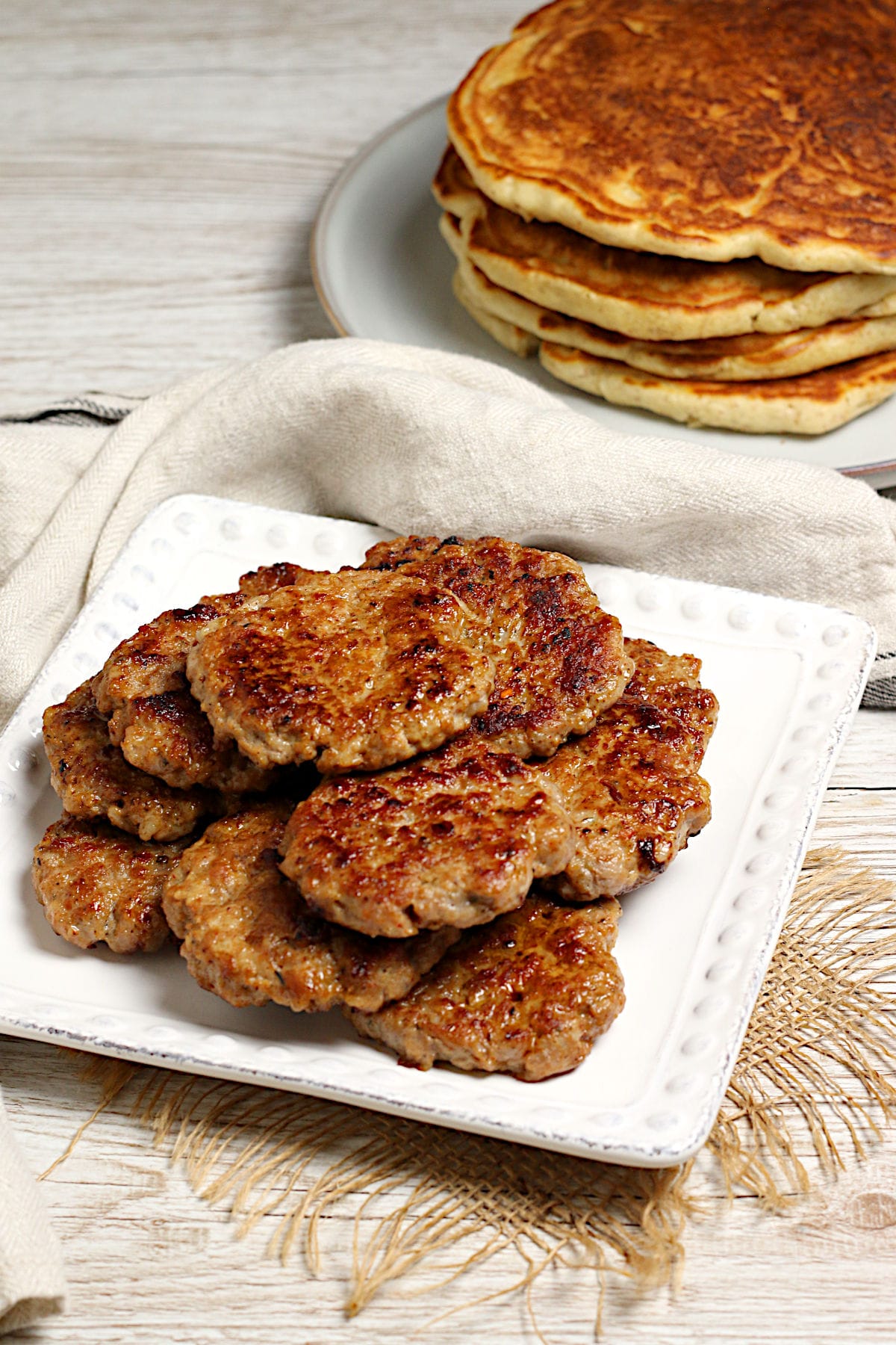 A stack of Homemade Breakfast Sausage Patties on a white plate.